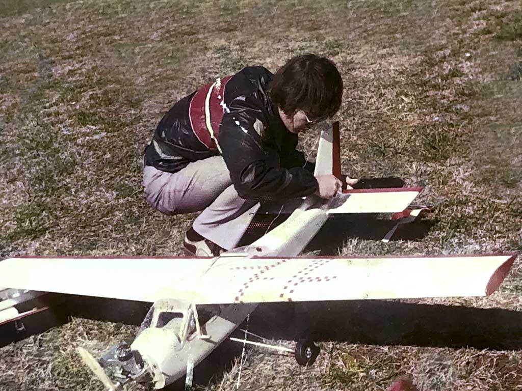 Photo of a John bent over a Midwest Cardinal Squire powered by a Fox 59 and controlled with an Orbit radio ca. 1973