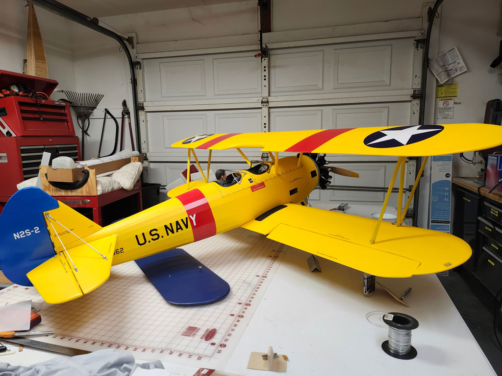 Wide anle photo of an assembled Ziroli 5th scale Stearman setting on a workbench as viewed from the right rear quarter