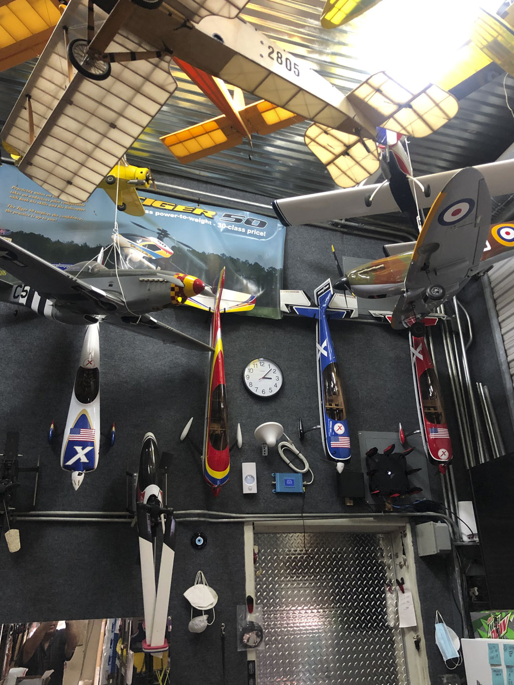Wide angle photo of models fuselages hanging in the foyer near the man door for easy access