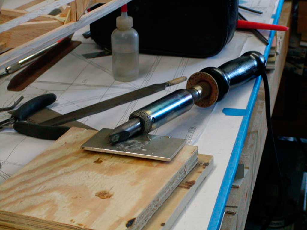 Close up of a 100W soldering iron for soldering together wire pieces of landing gear for a model airplane.