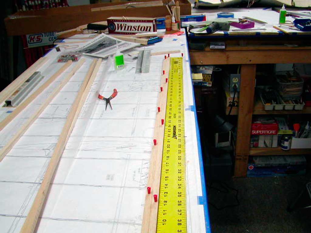 Close up of wing spar pinned to plans for a BUSA Morane-Saulnier model.
