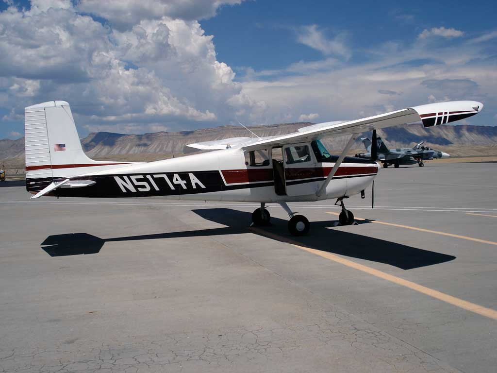 Close up of 1956 Cessna 172 with F/A-18 in the background.