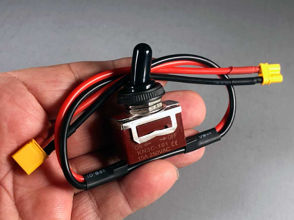 Hand holding a ProModeler waterproof toggle switch with XT30 connectors.