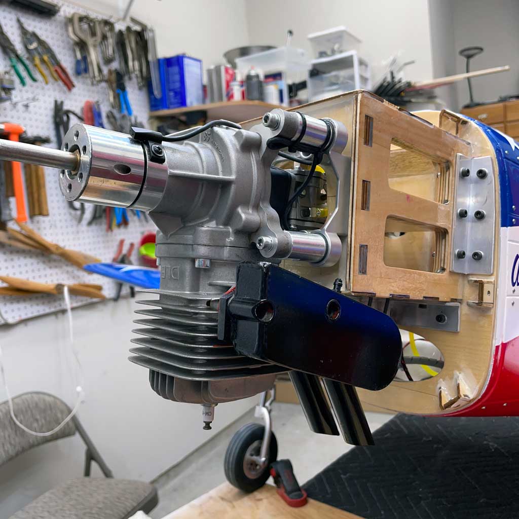 Close up of a DLE85 engine mounted to the firewall of a CY Models 96" P-51 Mustang finished in the red, white, and blue of the legendary Miss America Reno air racer.