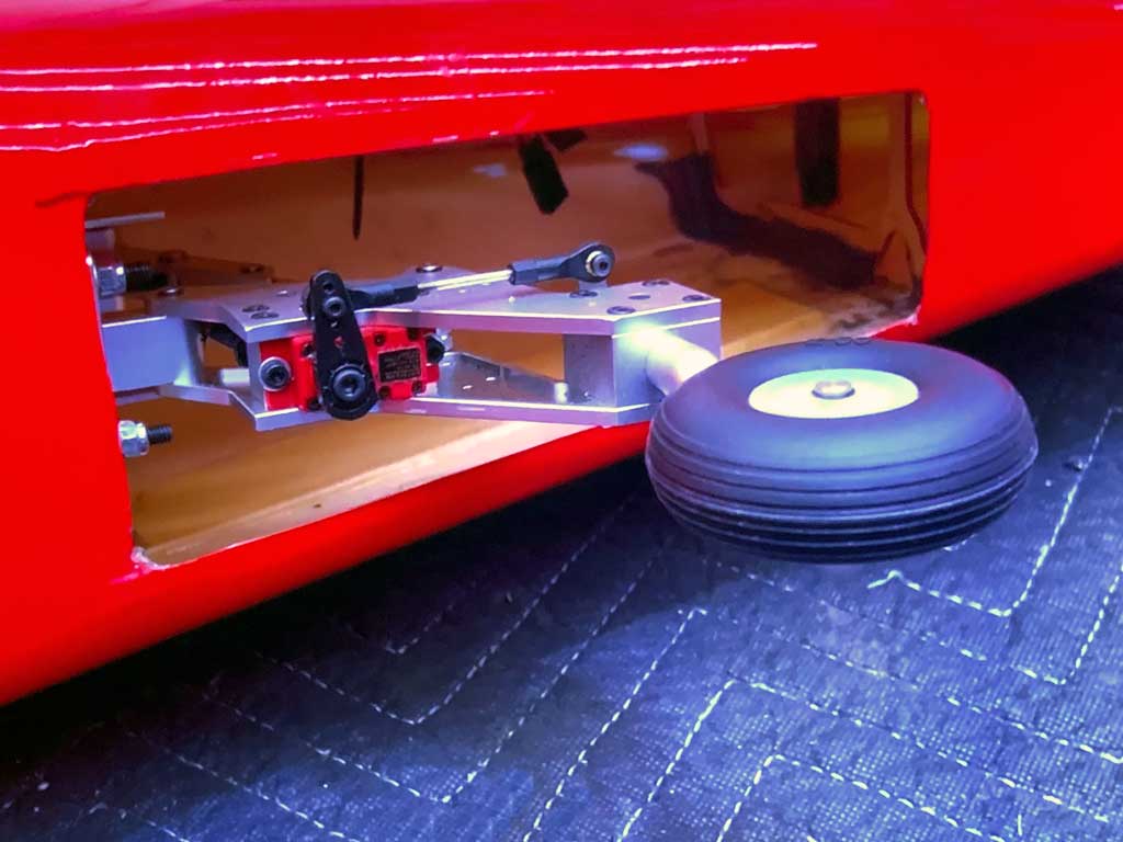 Close up of the electric retracting tail gear assembly installed on the aft bulkhead of the CY Models P-51 Mustang includes scale looking wheel with rubber tire and is driven by a ProModeler DS75CLHV submicro servo.