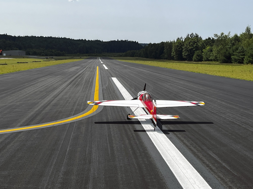 Wide angle aft photo of Goldwing 106-inch Yak 55M on the runway centerline