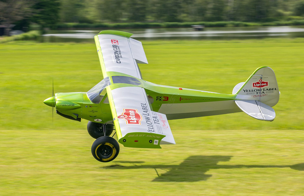 Low flyby photo of 4.3m clipped wing Badan Carbon Cub sporting 400mm tundra tires