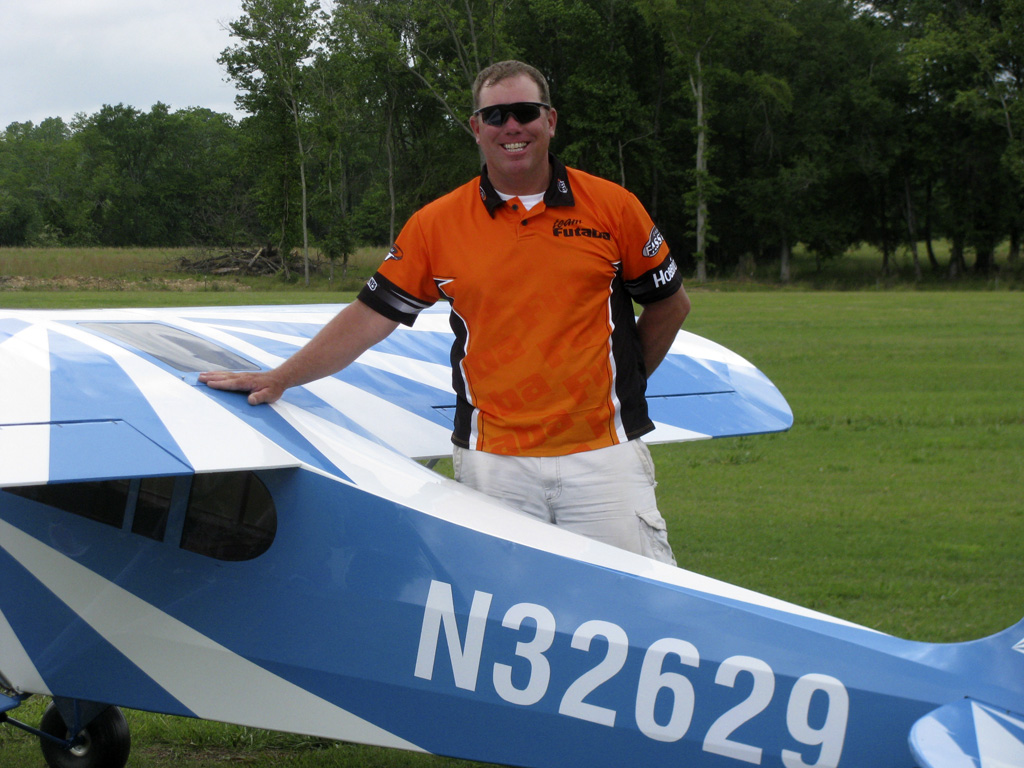 Photo of Bill Hempel of team Edge standing besides one of his 60% Clipped Wing Cub models