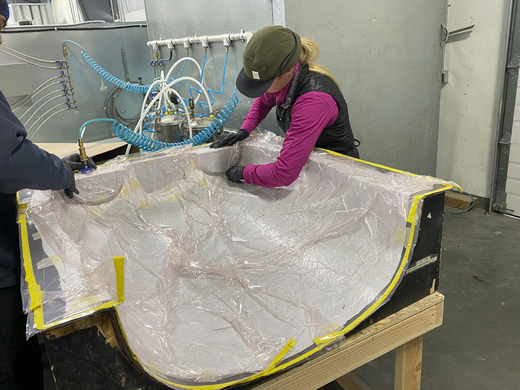 Photo of Jackie Burch laying up prepreg carbon fiber into a mold