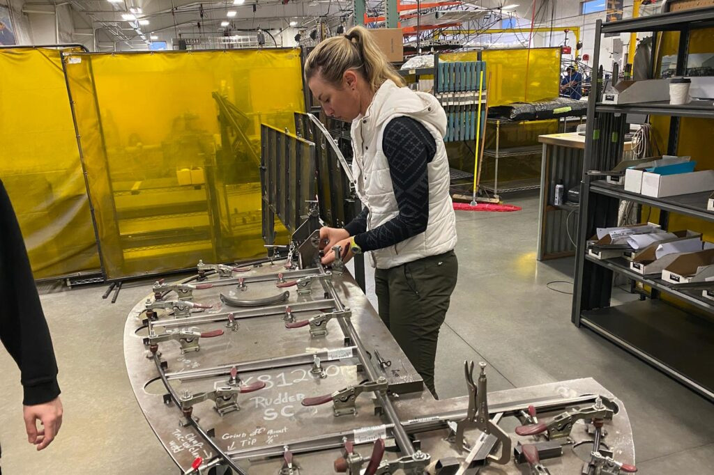 Photo of Jackie Burch particpating in Cubcrafters' builder assit program, this time working on a rudder
