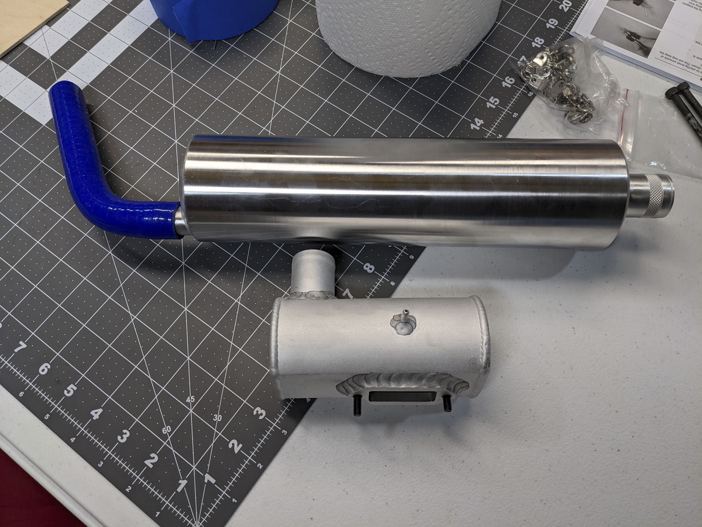 Photo of muffler besides an exhaust canister