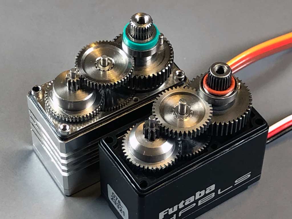 Close up photo of Fuatba HPS-A703 vs ProModeler DS930BLHV, both featuring spot welded compound gears