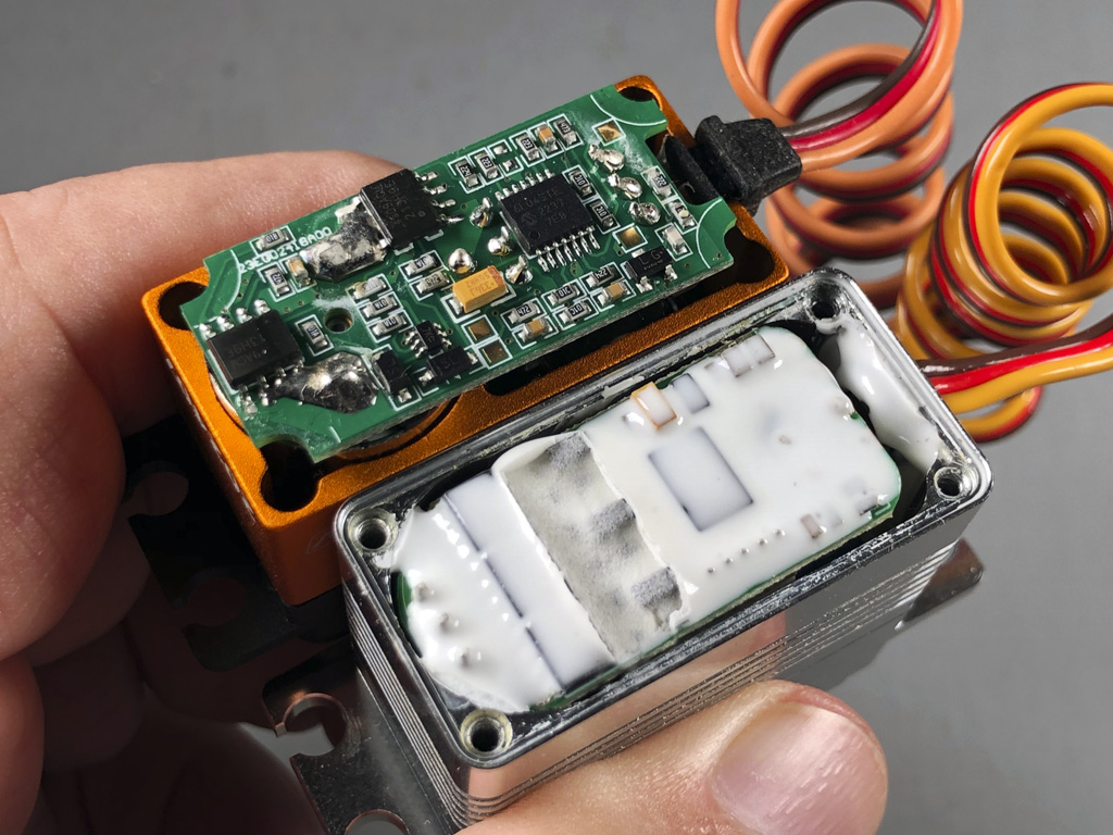 Close up photo comparing the PCB of the SAVOX SV1270TGP to a ProModeler DS630BLHV to show my customers get better vibration protection with ProModeler servos