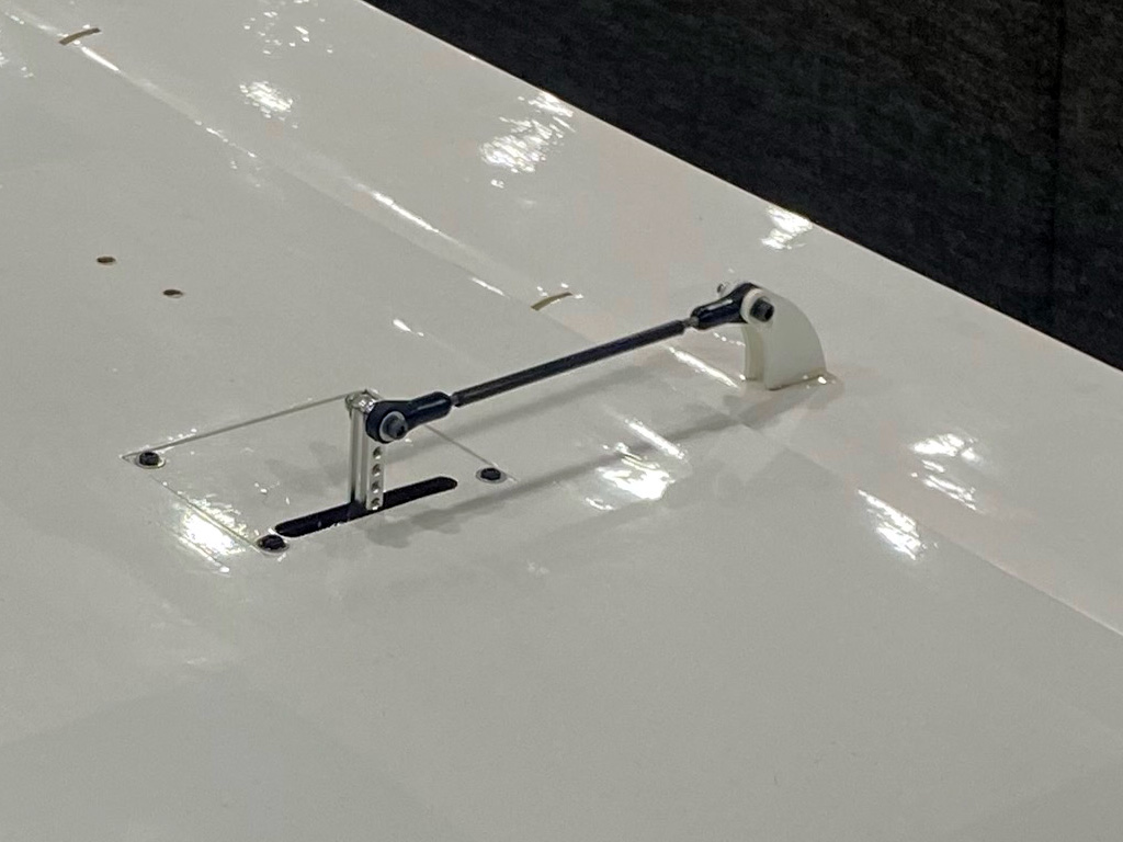 Close up photo of aileron servo installed on a hatch and buttons up so all that's visible is the linkage