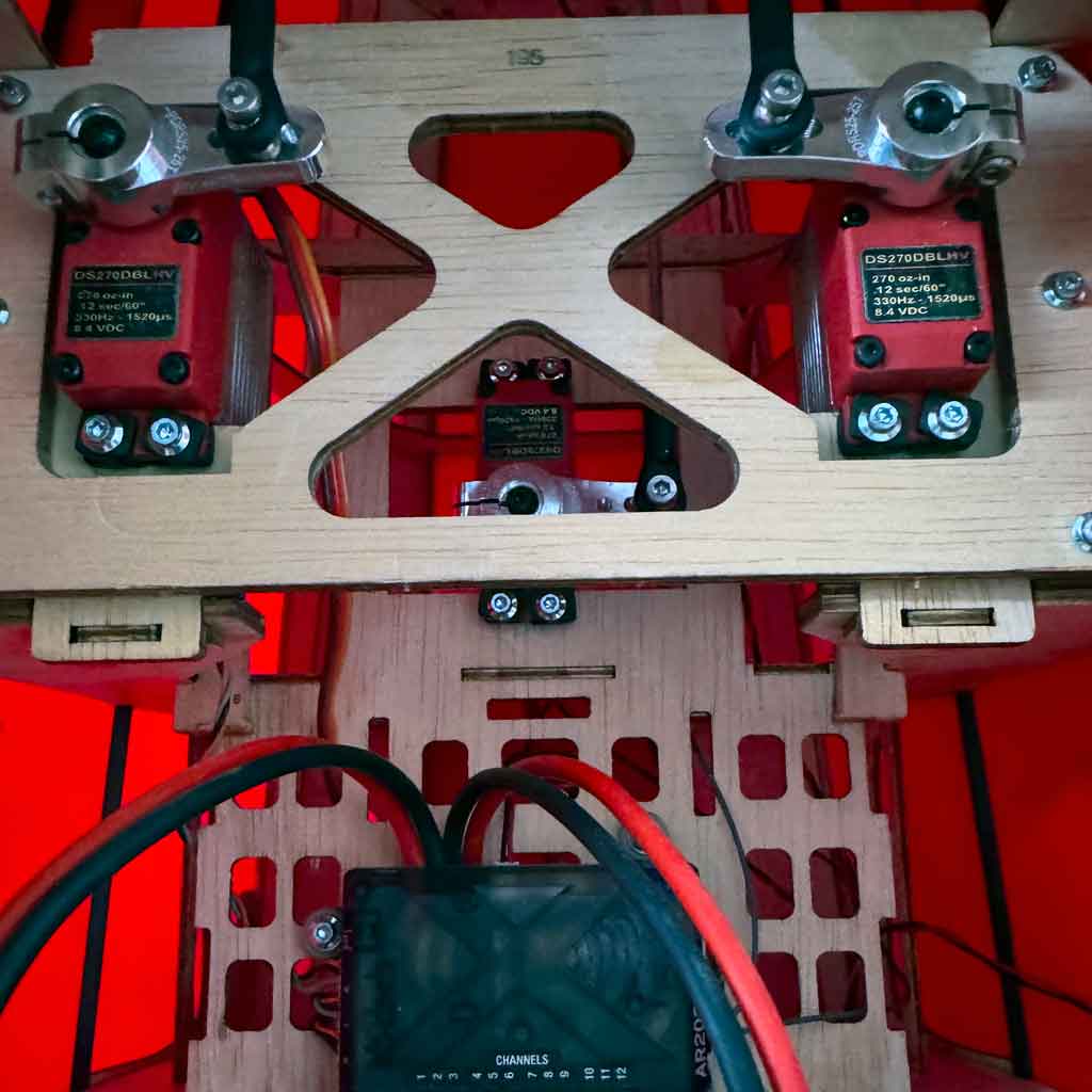 Close up of ProModeler DS270DLHV servos mounted within fuselage of Hangar 9 Pitts S-2B biplane connected to two individual elevator pushrods plus one to pushrod rudder, all activated through ProModeler PDRS25-25T servo horns.