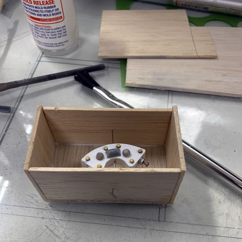 Close up of a brake caliper within a balsa box in preparation for molding