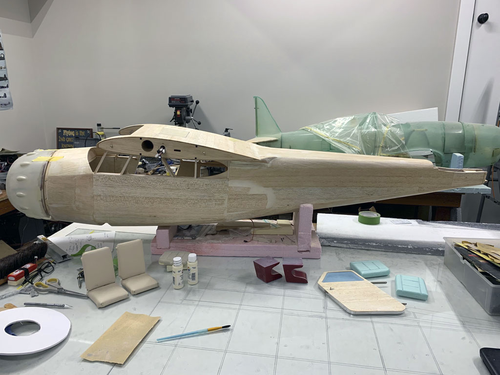 Close up photo of the fuselage construction of the Hostetler quarter scale Cessna 195 showing the balsa fuselage covered in fiberglass and with cowl mounted