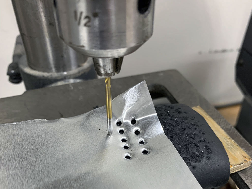 Close up photo of rivet heads being made using a bench top drill press and a reversed drill bit for the Hostetler quarter scale Cessna 195 model