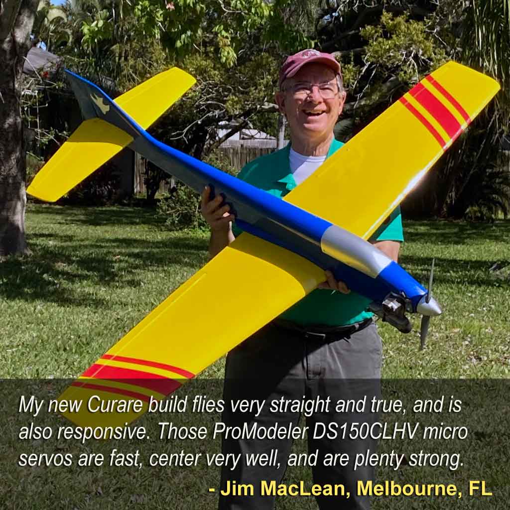 Man holds yellow and blue Curare competition model whilst wearing a smile of joy.