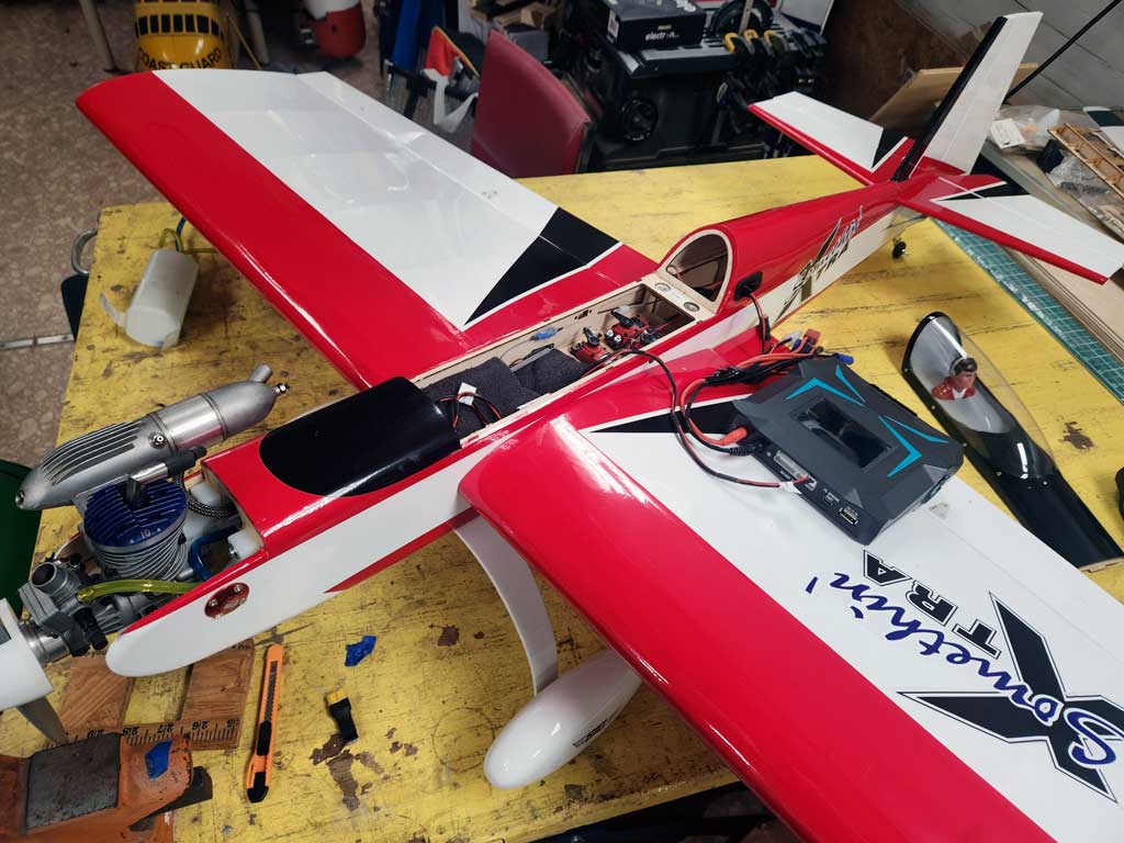 Close up of three ProModeler DS90DLHV servos mounted within fuselage of SIG Somethin' Extra model airplane for controlling rudder, elevator, and throttle.