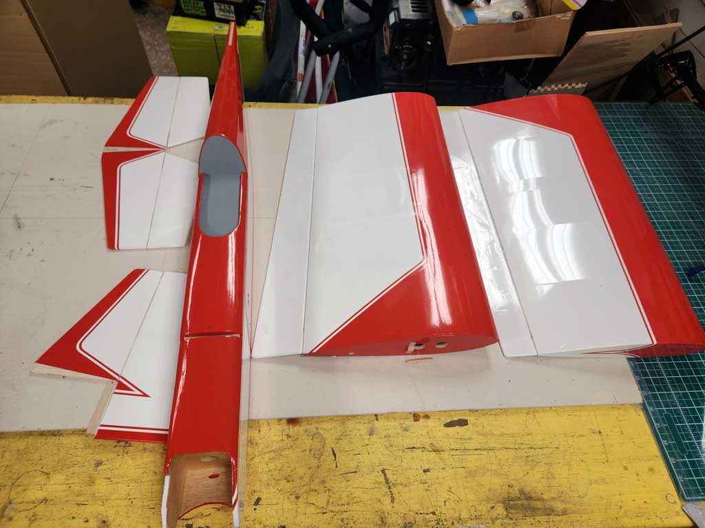 Components for the SIG Somethin' Extra ARF in red and white arranged on a table.