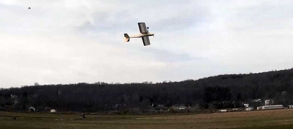 SIG Four-Star 40 flies inverted left to right at the model flying field.