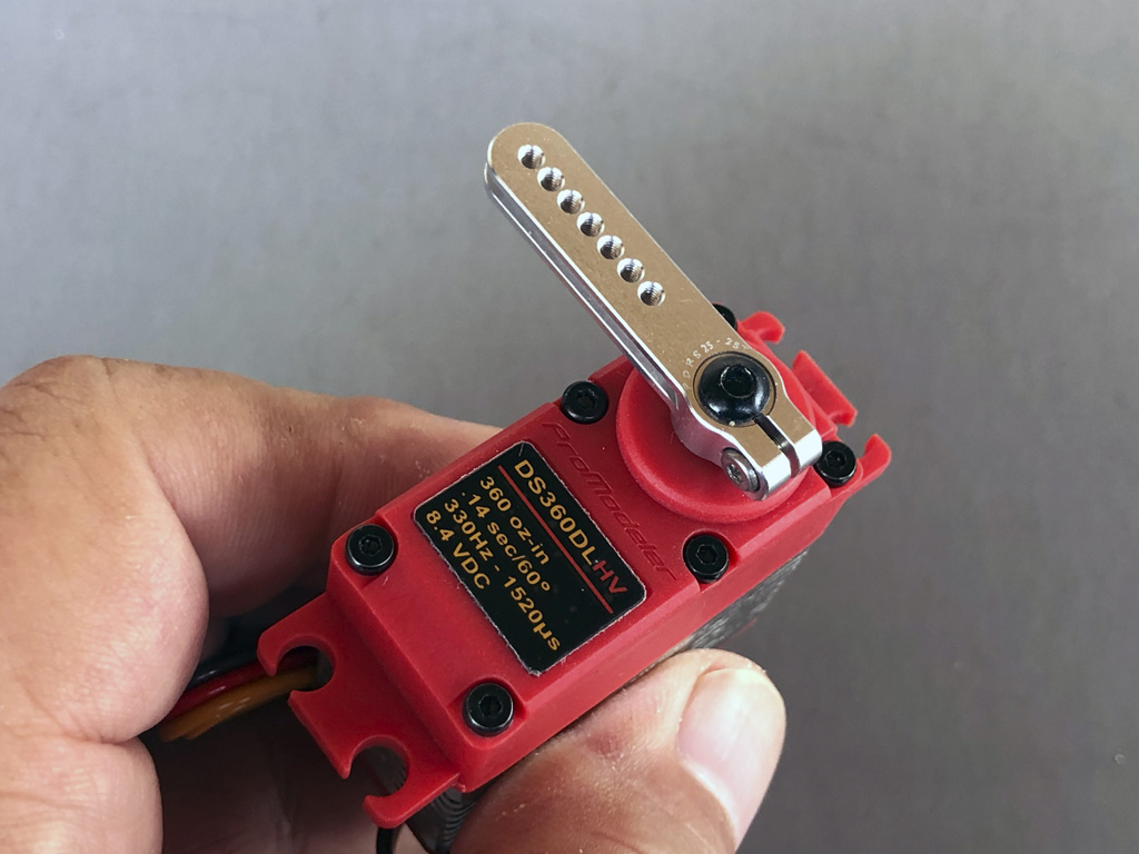 Close up photo of fingers holding a ProModeler DS360DLHV servo with PDRS25-25T with backlash compensation
