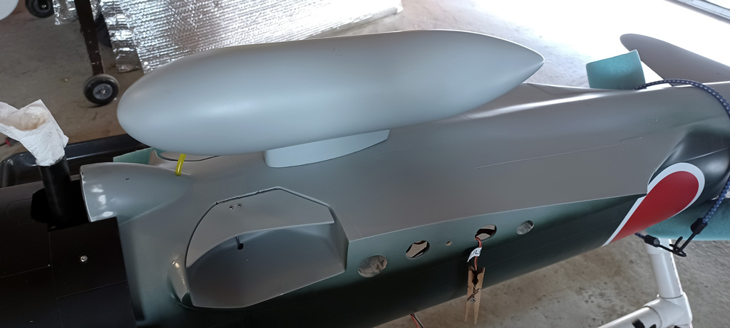 Close up photo of the underside ff the fuselage showing the drop tank and pushrods to operate the inner gear well doors for the TopRC Models 5th scale A6M5 Zero