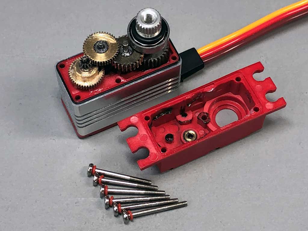 Close up of a ProModeler micro servo showing all-metal gears, bronze hardpoint supporting an intermediate gear shaft, and machine thread fasteners equipped with o-rings to protect against environmental intrusion.