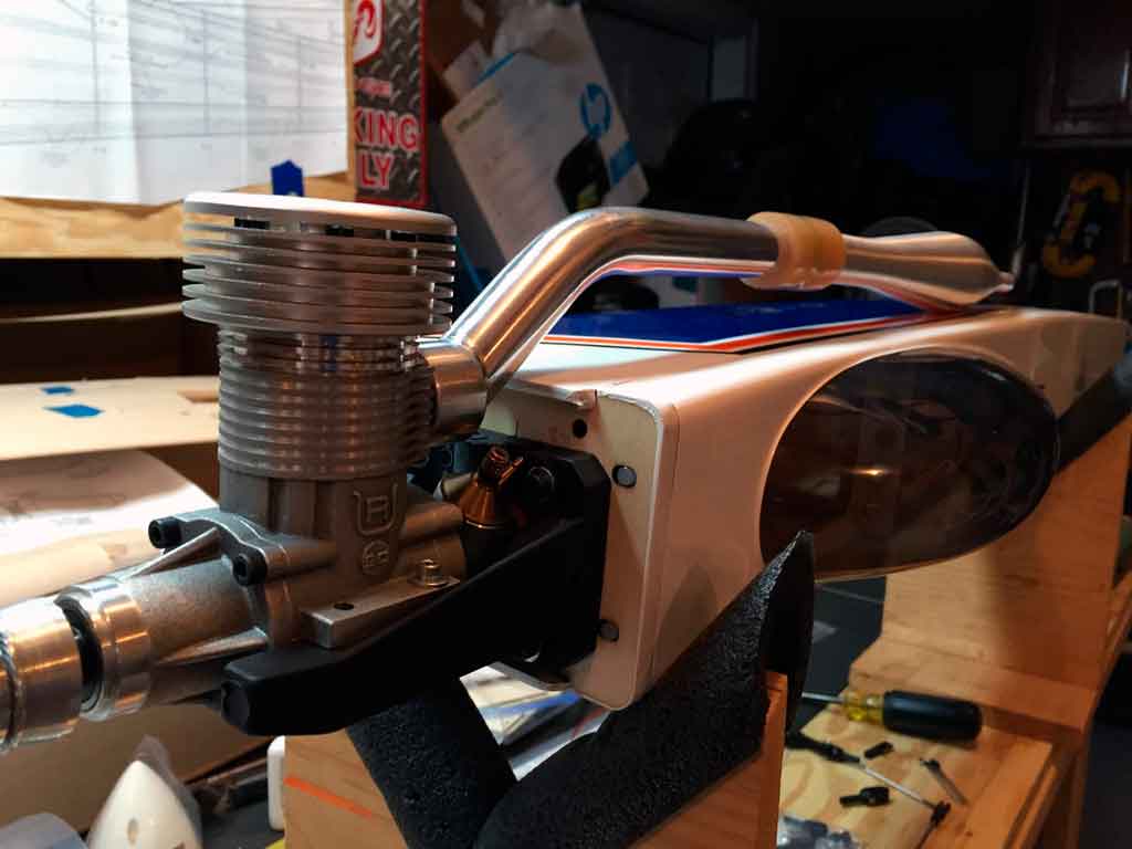 Close up of side mounting a Rossi 90 with tuned pipe header in a Tower Hobbies 62in Kaos.