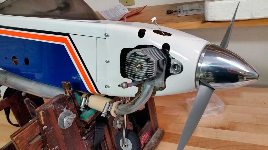 Close up of side mounting an OS MAX 65AX with tuned pipe in a Tower Hobbies 62in Kaos.