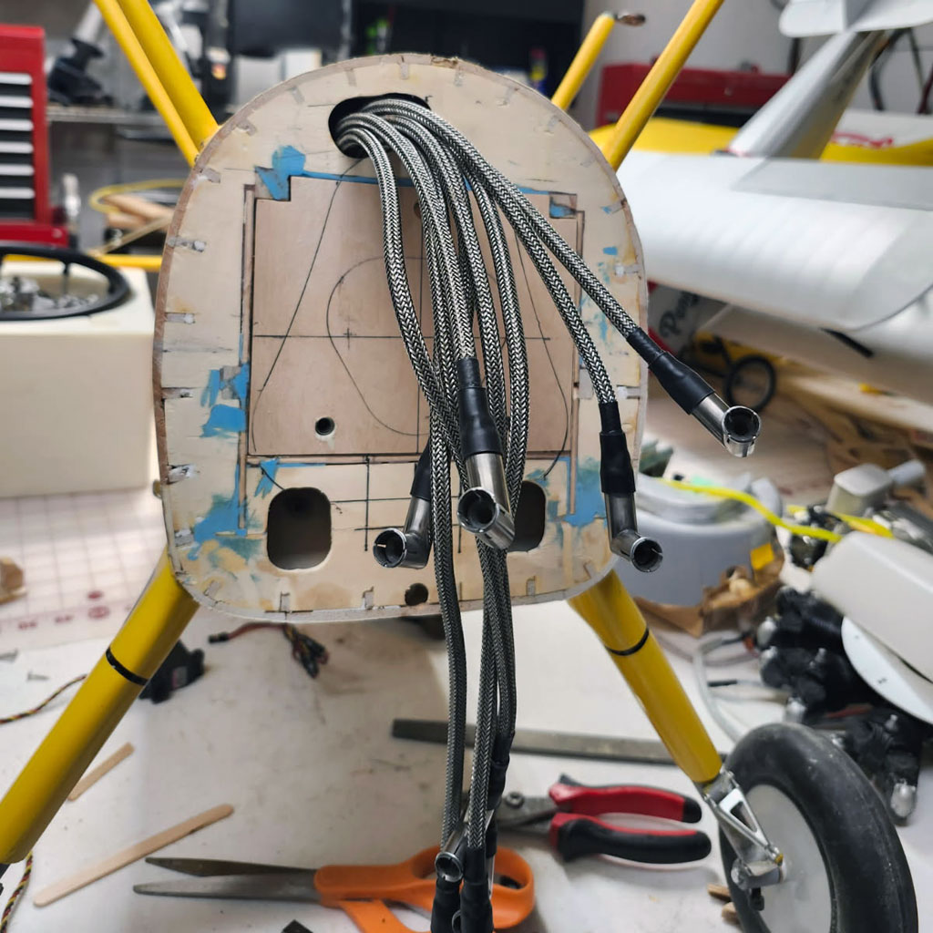 Close up photo of the firewall finally epoxied in place on the 1/th scale Ziroli Stearman PT-17 with the 9 spark plug leads protruding through the forward part of the aircraft