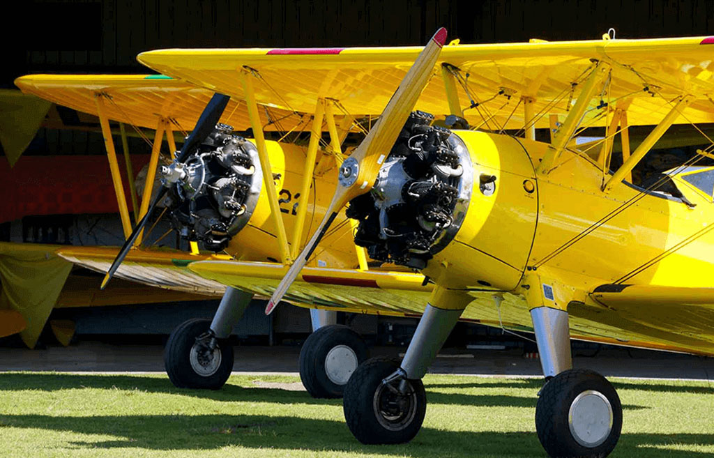 Photo of a pair of Stearman biplanes painted in yellow Stits paint