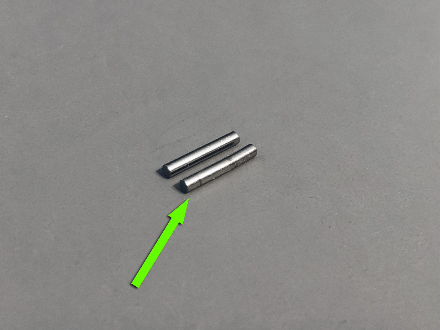 Close up of two gear shafts, one new, the other bend due to crash damage