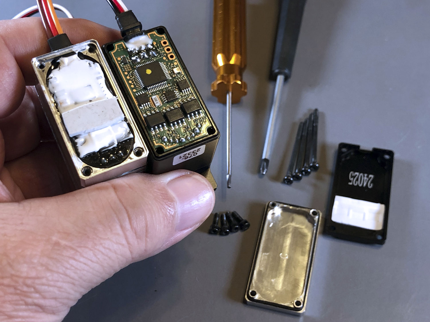 Close up photo showing the PCBs of both the Futaba HPS-A703 and ProModeler DS930BLHV to showcase the amount of protective potting compound on the ProModeler circuit board