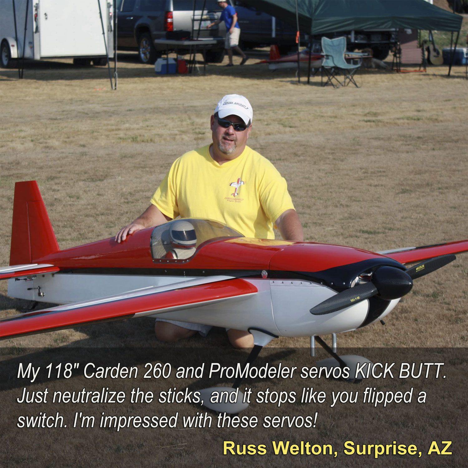 Close up of Russ Welton kneeling with his giant scale Carden 260 stating, 'My 118" Carden 260 and ProModeler servos KICK BUTT. Just neutralize the sticks, and it stops like you flipped a switch. I'm impressed with these servos!'