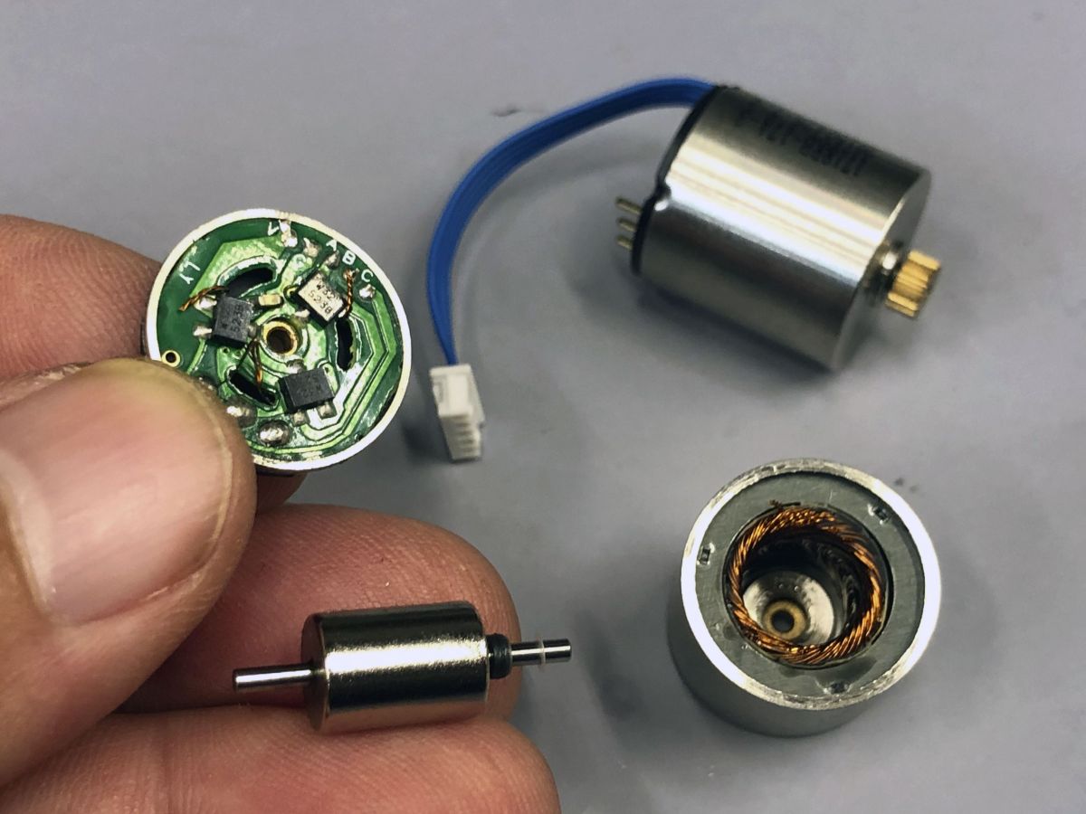 Close up photo of three different ProModeler servo motors juxtraposed with an automotive condensor