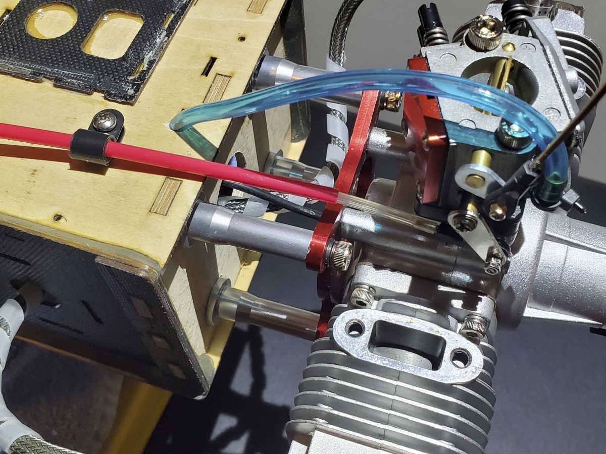 Close up of engine carburetor operated through a steel rod by a servo mounted to the motor box
